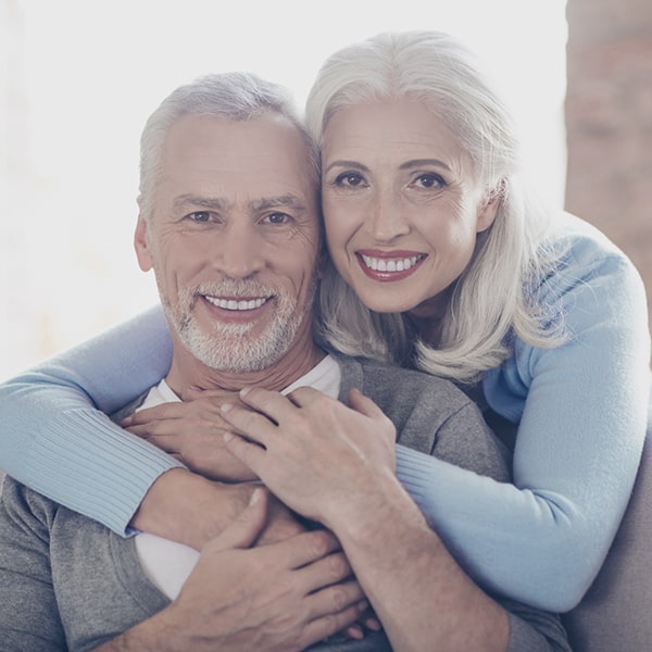 A mature couple smiling after periodontal therapy