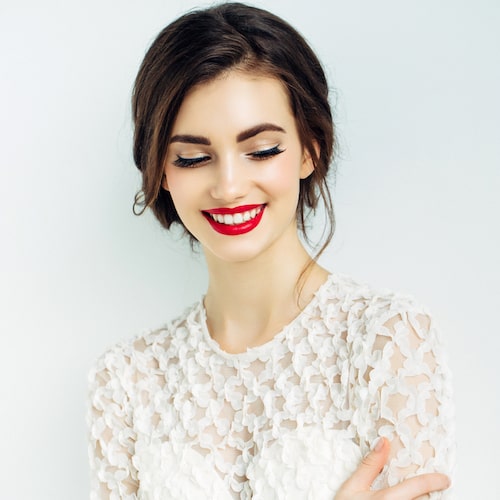 A young woman with bright red lipstick and a big white smile